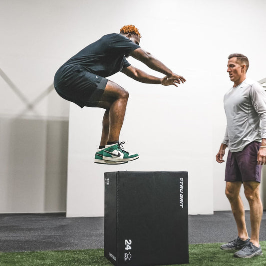 Athlete performing an explosive box jump in a gym