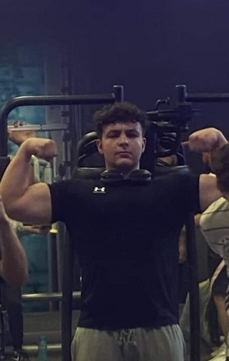 Bodybuilder Marwan Yahiaoui posing in front of a gym mirror during training