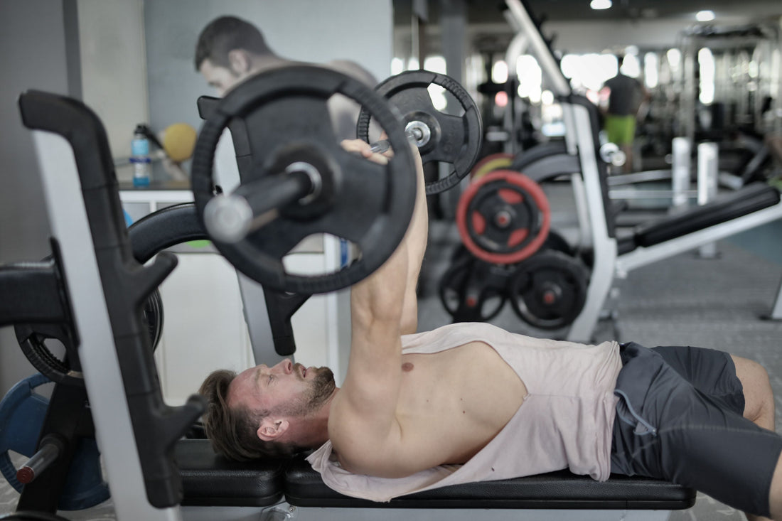 Athlete performing a heavy barbell bench press in the gym