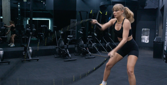 Taylor Swift performing battle-rope conditioning in a gym
