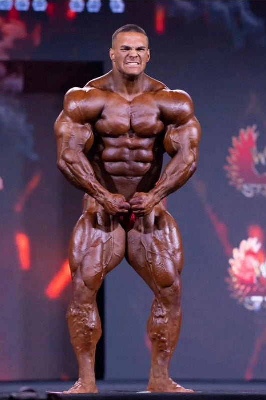 Nick Walker posing onstage after winning the 2026 Mr. Olympia Men’s Open title