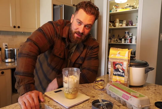 Chris Bumstead-style bodybuilding meal prep with lean protein, rice, vegetables and prepared containers in a bright kitchen