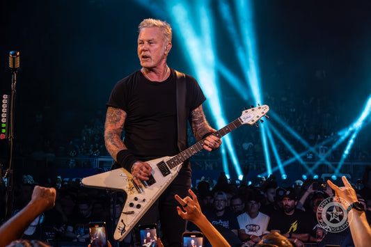 James Hetfield playing fast rhythm guitar onstage with tattooed right forearm visible