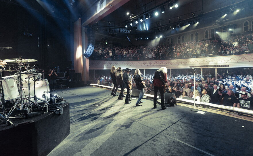 Lynyrd Skynyrd live onstage in the 1970s, capturing the Southern-rock attitude behind the pump-cover look