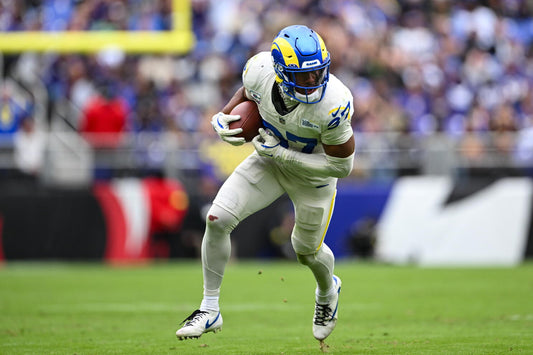Los Angeles Rams safety Quentin Lake running with the football in a white and blue uniform during a game
