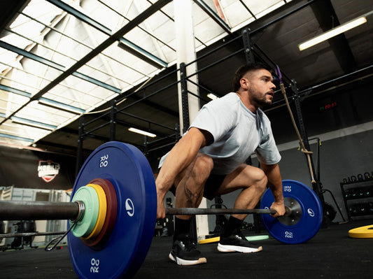 Athlete preparing a loaded barbell deadlift on a lifting platform