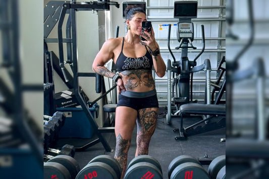 Rhea Ripley flexing her muscular arms in a gym