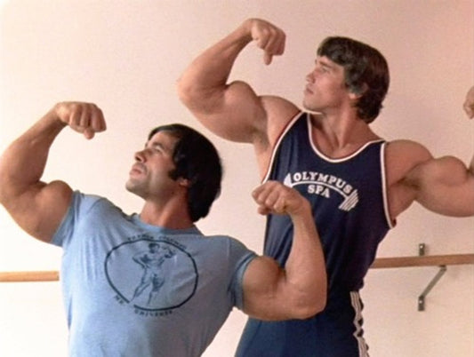 Arnold Schwarzenegger and Franco Columbu flexing side by side in vintage training tops